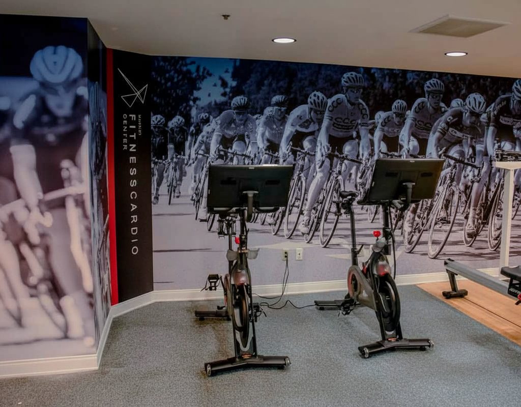 Hotel fitness center cardio room full-wall mural featuring cycling imagery installed by American Window Film