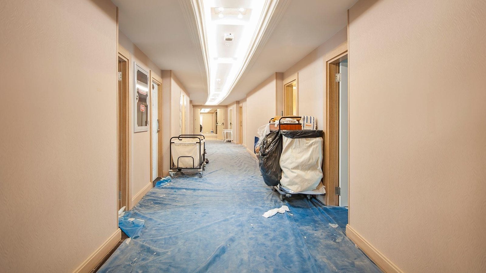 Hotel corridor mid-renovation with painter's tarp blocking guest access — the disruption AWF eliminates