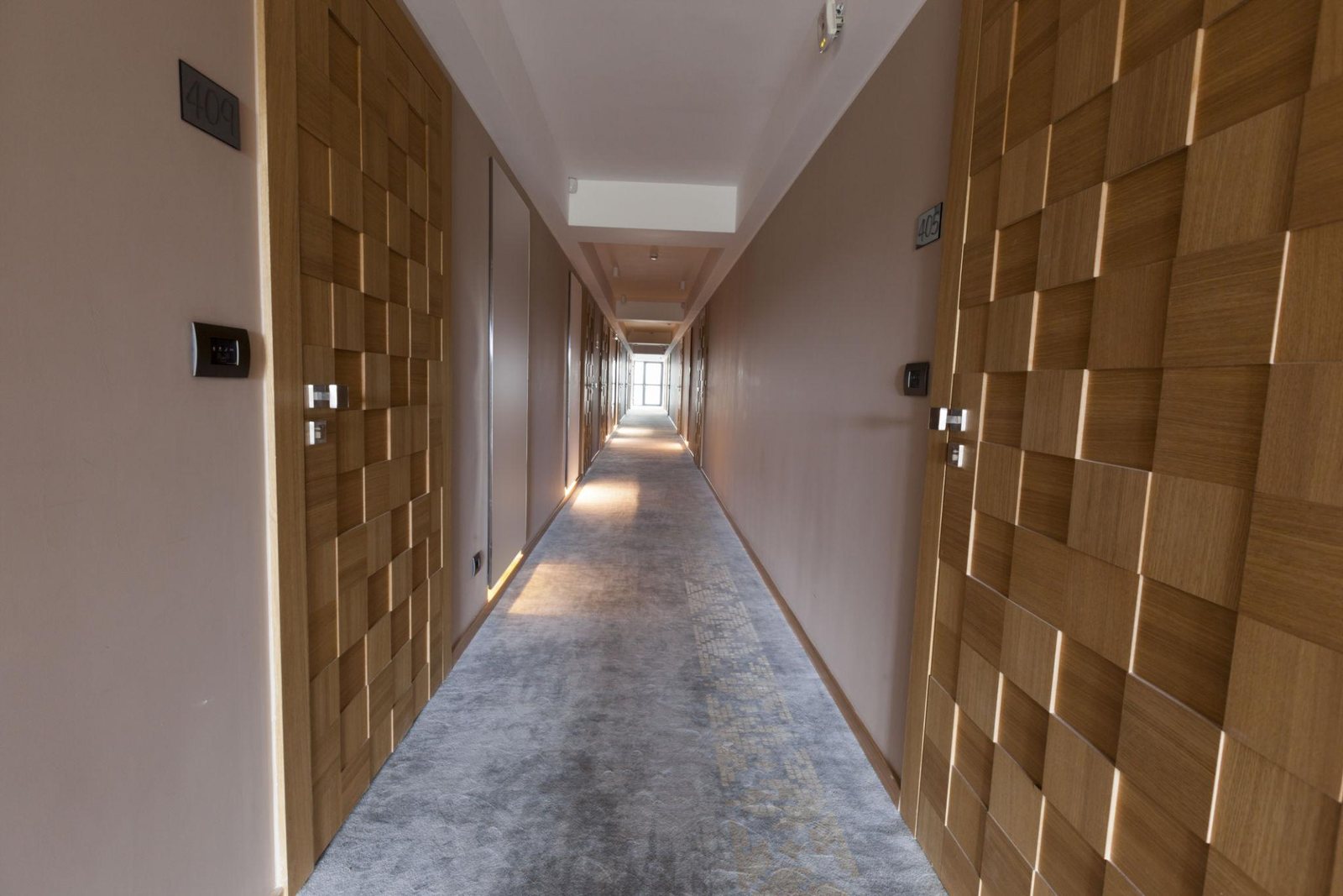 Premium hotel corridor with floor-to-ceiling glass and DI-NOC accent panels — AWF solar film and architectural finishes